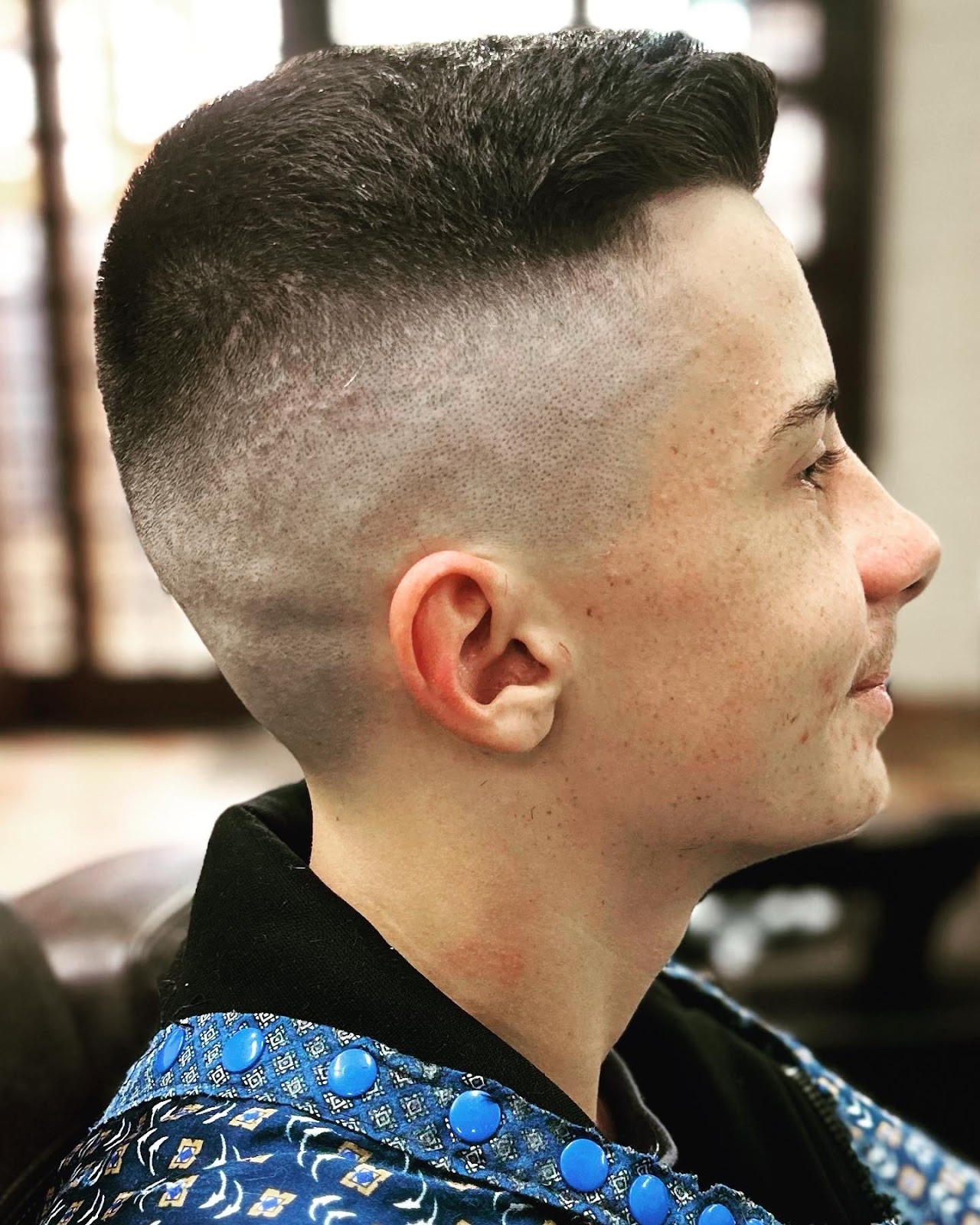 Corte de cabelo masculino finalizado na Barbearia André, com risco lateral bem definido