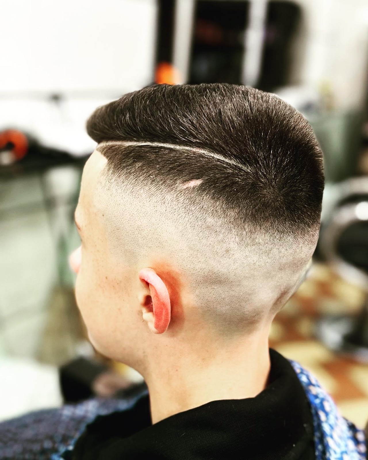 Corte na Barbearia André mostrando o redemoinho natural no alto da cabeça, com o risco cortado ao redor